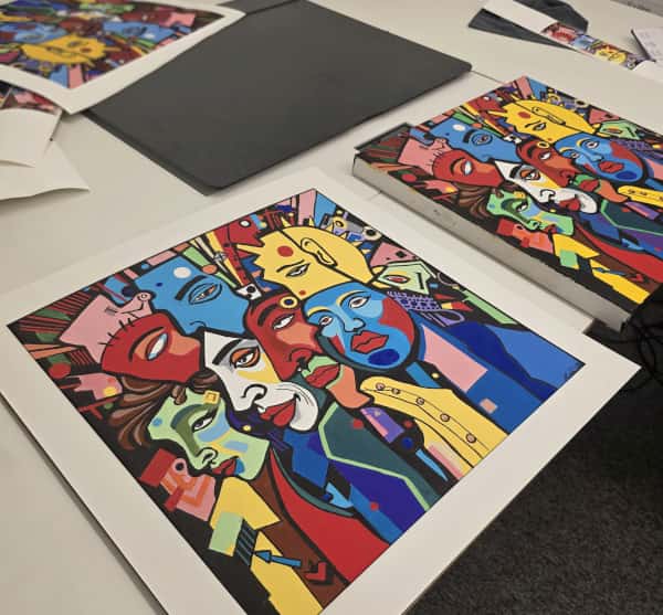 An original painting beside its colour-matched reproduction prints in the Love to Frame studio